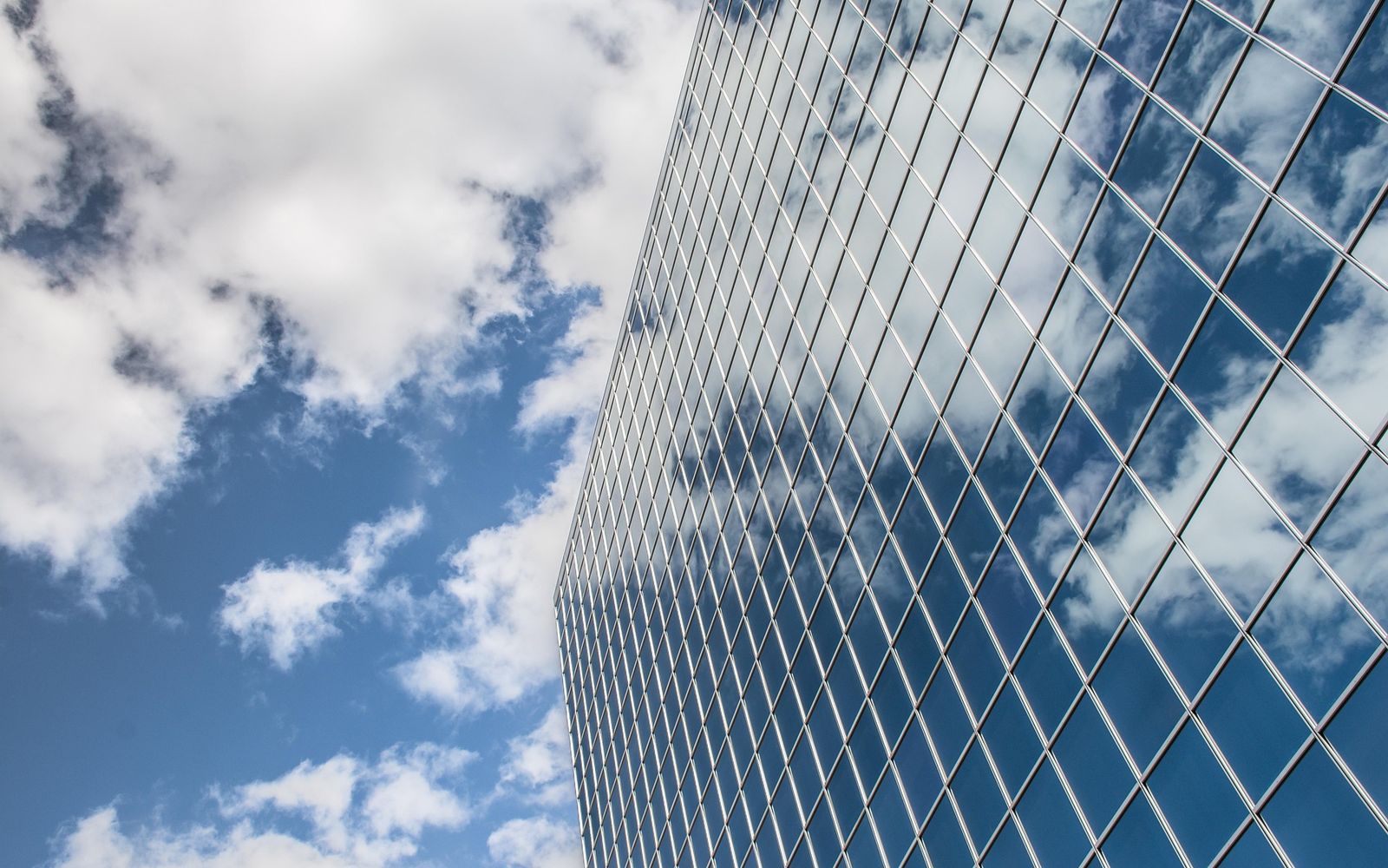 Façade vitrée d’un immeuble reflétant le ciel